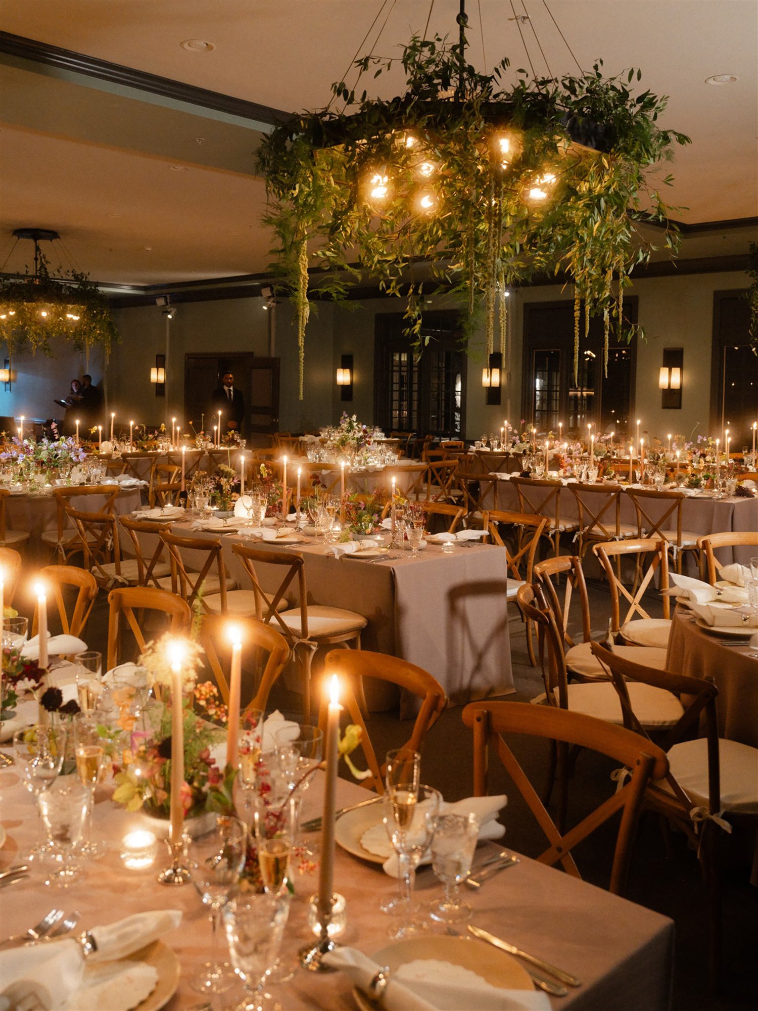 Candlelit reception dinner beneath hanging greenery